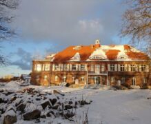 Das Schloss im Winter Die Wintersonne zeigt eine Rückfassade mit der fertigen Terrasse und dem Balkon.